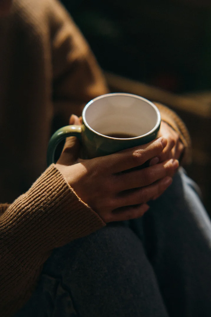 Hands cradling a stoneware mug